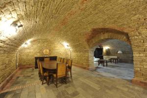 a dining room with a table and a brick wall at Conac Polizu in Maxut