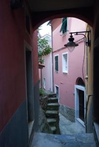 an archway in an alley between two pink buildings at Cà de Lelio in Manarola