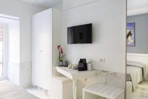 a white living room with a tv on a wall at Little Aurelius in Rome