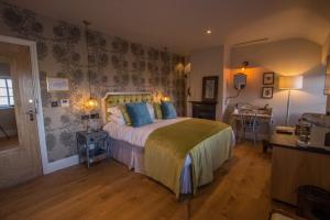 a bedroom with a large bed with blue pillows at The Peacock at Barlow in Chesterfield