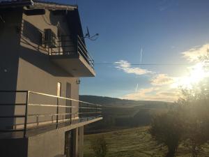 a building with a balcony with the sun in the sky at VIP Apartments & Room in Rakovica