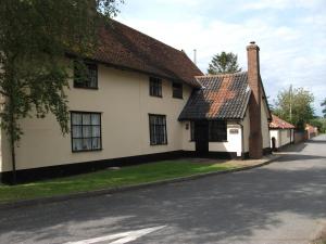 uma casa branca com um telhado castanho numa rua em Withersdale Cross Cottages em Mendham