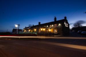 a building with lights on the side of a street at The Peacock at Barlow in Chesterfield