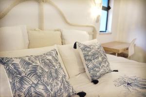 een wit bed met twee kussens erop bij Palmeira VIP Apartment in Portimão +24 foto's