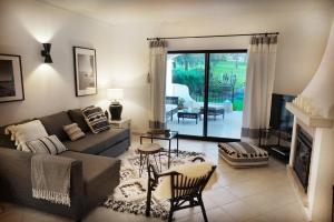 a living room with a couch and a fireplace at Palmeira VIP Apartment in Portimão