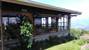 a building with windows on the side of a hill at Finca Y Granja Loma Bonita in Turrialba