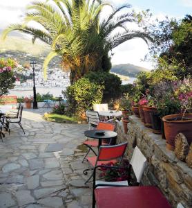 a patio with chairs and tables and plants at Blue Dolphin in Batsi