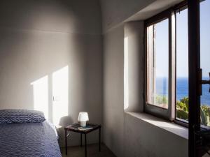 a bedroom with a bed and a view of the ocean at Dammuso sulla scogliera - Pantelleria in Scauri