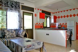 a living room with a couch and a kitchen at Résidence Rive D'or in Martil +20 photos