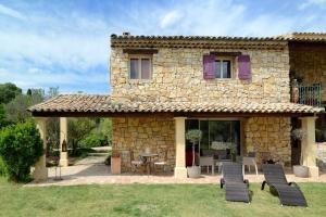 une maison en pierre avec des chaises et une table devant elle dans l'établissement Suite de l'olivier au Mas au Coeur de la Provence &SPA, à Saint-Cannat