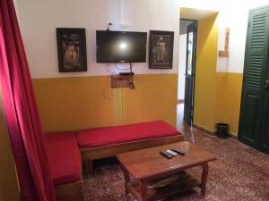 a living room with a red couch and a tv at Chez Eric in Gorée