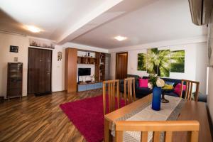 Rox Central Apartments في تيميشوارا: غرفة معيشة مع طاولة وغرفة طعام
