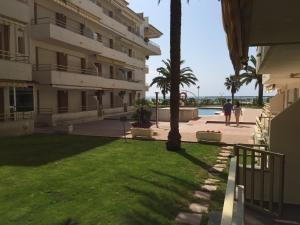 un bâtiment avec une pelouse verte devant un bâtiment dans l'établissement Apartaments Colibri, à Cambrils