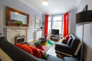 sala de estar con sofá y chimenea en PREMIER - Crathie View Apartment en Glasgow