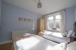 Habitación con 2 camas y ventana en PREMIER - Crathie View Apartment en Glasgow