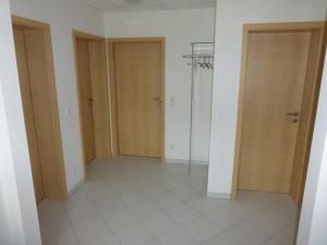 ein leeres Zimmer mit zwei Türen und Fliesenboden in der Unterkunft Ferienwohnung Unica im Lahntal in Villmar