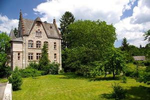 an old stone house with a green yard at Ferienwohnung Unica im Lahntal in Villmar