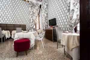 a restaurant with tables and chairs and a television at Hotel Ca' Nobile Corner in Venice