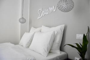 una camera da letto con un letto bianco con cuscini bianchi di Standard Apartment by Hi5 - Fejer Gyorgy St a Budapest