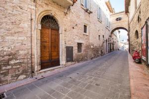 un callejón con una moto roja estacionada junto a un edificio en Bed and Breakfast Sognando Te, en Asís