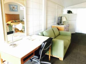 um quarto com um sofá e um espelho em Warm Mineral Springs Motel em North Port