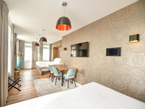 a living room with a table and chairs at Brasserie-Hotel Antje van de Statie in Weert