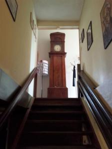 a staircase with a grandfather clock in a building at Hostel Herberg de Esborg Scheemda in Scheemda