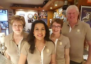 a group of people posing for a picture in a bar at Hostel Herberg de Esborg Scheemda in Scheemda