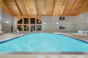 a swimming pool in a building with a wooden ceiling at Baymont by Wyndham Baxter/Brainerd Area in Baxter