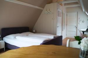 a small bedroom with a bed and a table at Bij de Buren in Enkhuizen