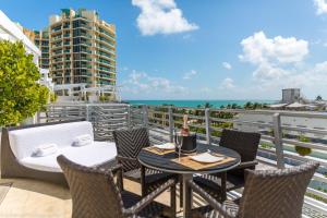 einen Balkon mit einem Tisch, Stühlen und Meerblick in der Unterkunft SBV Luxury Ocean Hotel Suites in Miami Beach