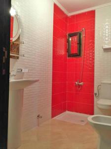 baño rojo con ducha y aseo en Résidence Rive D'or, en Martil