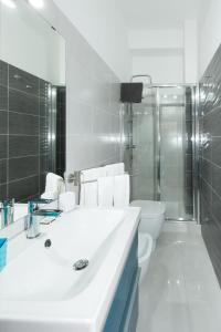 a white bathroom with a sink and a toilet at B&B Albergo Sicilia in Avola