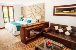 a hotel room with a bed and a couch at Hotel Virrey Park in Bogotá