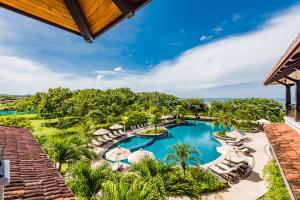 uma vista aérea de uma piscina do resort com espreguiçadeiras em Luxury Vacation Rentals At Hacienda Pinilla em Tamarindo