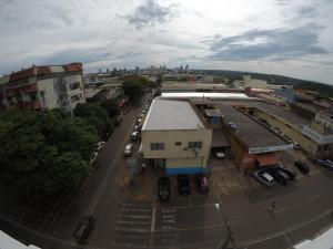 une vue aérienne sur une rue de la ville avec des voitures garées dans l'établissement Hotel Dove, à Foz do Iguaçu