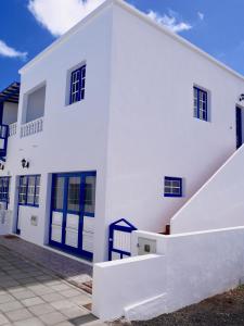 uma casa branca com portas azuis e escadas em Casa Suso & casa Margarita em Orzola