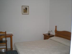 1 dormitorio con 1 cama, 1 mesa y 1 silla en Hostal Maurin, en Vilaller