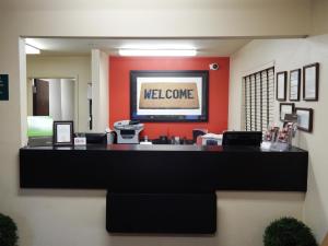 un vestíbulo con una señal de bienvenida en una pared roja en Extended Stay America Suites - Gainesville - I-75 en Gainesville