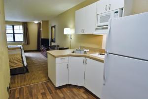 a kitchen with a white refrigerator and a room at Rosewood Hotel- Portland East in Portland