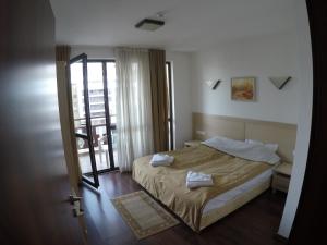 een slaapkamer met een bed met twee handdoeken erop bij Oksana's Apartment at Infinity in Bansko