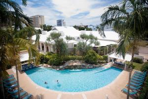 einen Blick über einen Pool mit Palmen in der Unterkunft Mantra Esplanade in Cairns