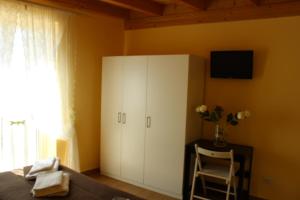 1 dormitorio con armario blanco y silla en Terrazza Sul Rabato, en Agrigento