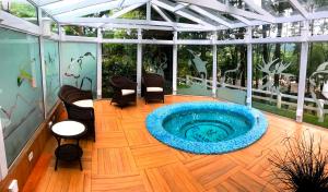 a hot tub on a patio with chairs on a wooden floor at Canada Lodge Campos do Jordão in Campos do Jordão