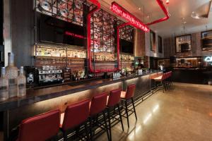 a bar with red chairs in a restaurant at Malmaison Birmingham in Birmingham