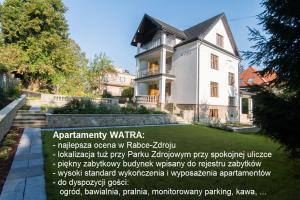 Biały dom z napisem przed nim w obiekcie Apartamenty Watra w Rabce