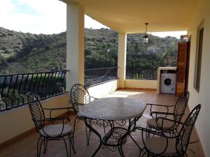 Un patio con una mesa y sillas en un balcón. en Apartamentos Vista La Maroma, en Viñuela