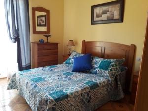 Un dormitorio con una cama con un edredón azul. en Apartamentos Vista La Maroma, en Viñuela