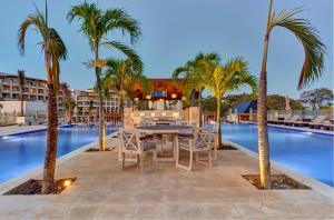 a patio with a table and chairs next to a pool at Hideaway at Royalton Saint Lucia, An Autograph Collection All-Inclusive Resort, Adults Only in Gros Islet