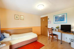 Zimmer mit einem Bett und einem Schreibtisch mit einem Computer in der Unterkunft Hotel Pension Stern in Bad Buchau